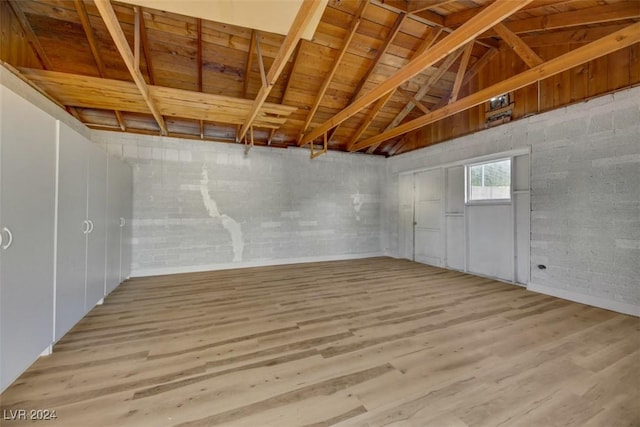 basement featuring light wood-type flooring and wooden ceiling