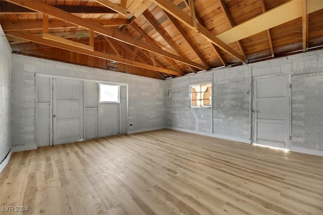 basement with wood ceiling and light hardwood / wood-style flooring