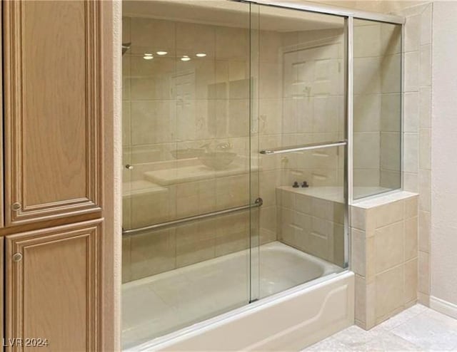 bathroom with shower / bath combination with glass door and tile patterned flooring