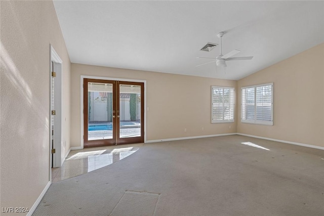 carpeted empty room featuring ceiling fan, lofted ceiling, and french doors