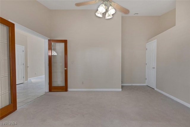 unfurnished room with light carpet, french doors, and ceiling fan