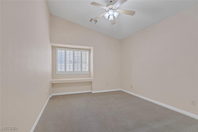 carpeted empty room featuring ceiling fan and vaulted ceiling