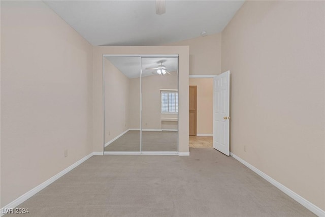 unfurnished bedroom with ceiling fan, light colored carpet, lofted ceiling, and a closet