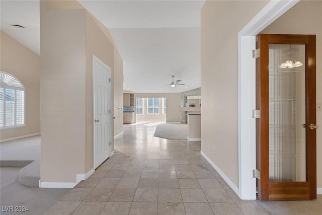 corridor with light colored carpet and vaulted ceiling