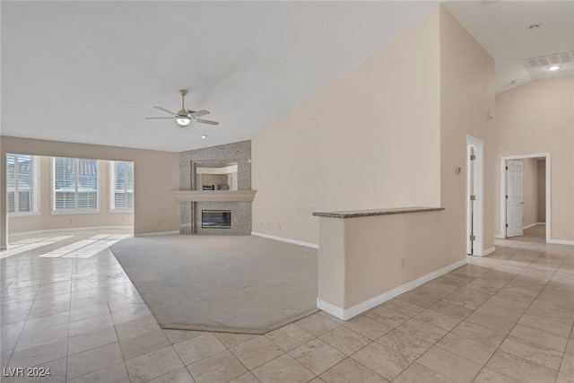 unfurnished living room with ceiling fan, light tile patterned floors, and lofted ceiling