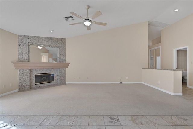 unfurnished living room with light carpet, a fireplace, and ceiling fan