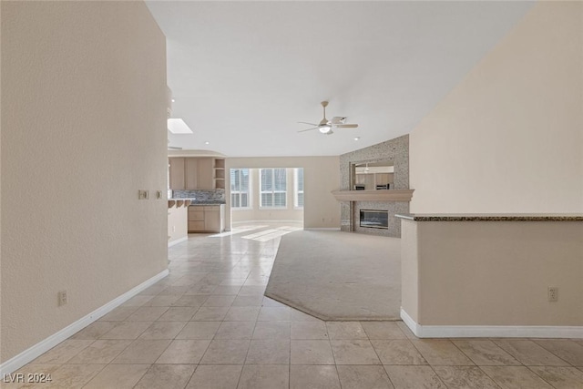 unfurnished living room featuring ceiling fan and light tile patterned floors