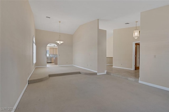 carpeted empty room featuring lofted ceiling