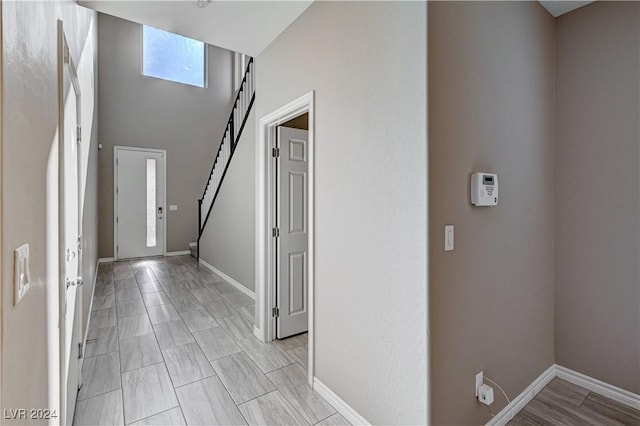 corridor featuring a towering ceiling and a wealth of natural light