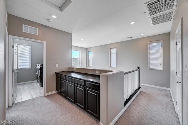 kitchen featuring light carpet and washer and dryer