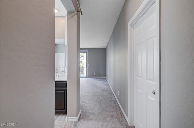 hallway featuring light colored carpet