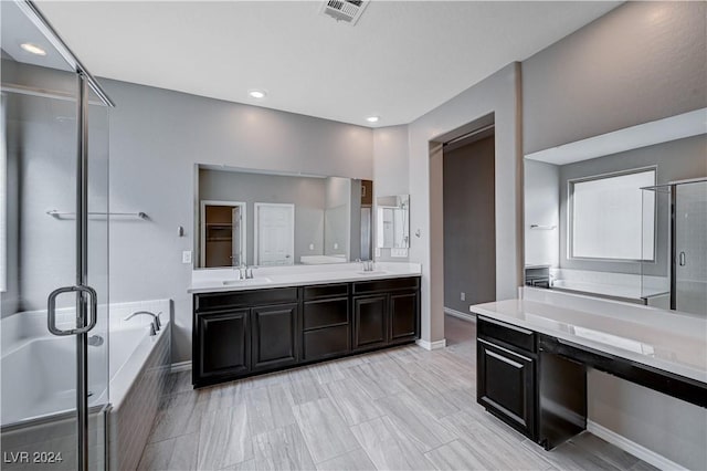 bathroom featuring vanity and independent shower and bath