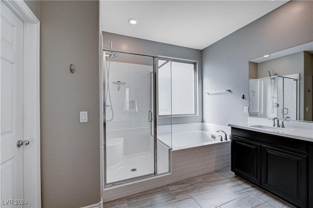 bathroom featuring vanity and independent shower and bath