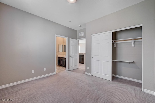 unfurnished bedroom featuring light carpet, connected bathroom, and a closet