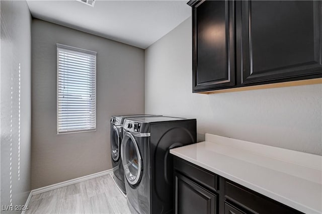 laundry room with washing machine and dryer and cabinets