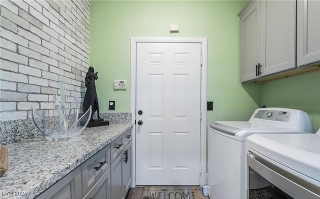 laundry area with cabinets, wood-type flooring, and separate washer and dryer