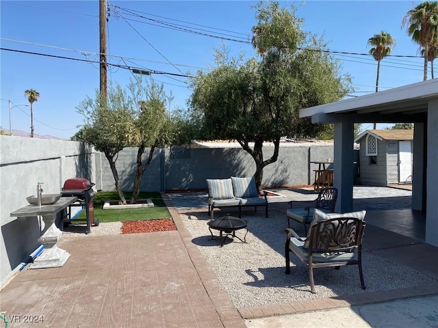 view of patio with a fire pit, a storage unit, and a grill