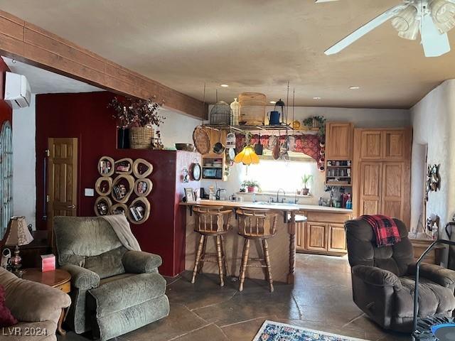 kitchen with a breakfast bar, sink, ceiling fan, kitchen peninsula, and a wall unit AC