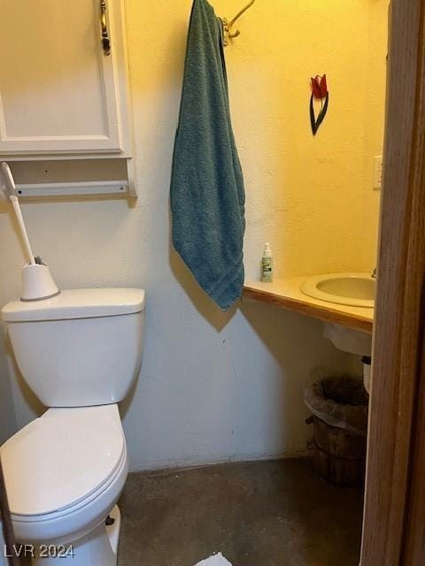 bathroom featuring toilet and concrete flooring