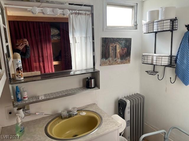 bathroom with radiator heating unit and vanity