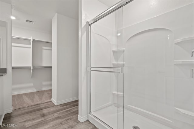 bathroom featuring hardwood / wood-style flooring and walk in shower