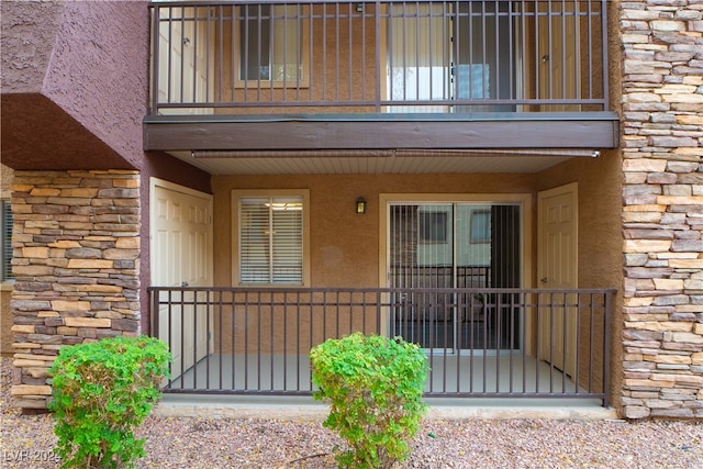 view of exterior entry featuring a balcony