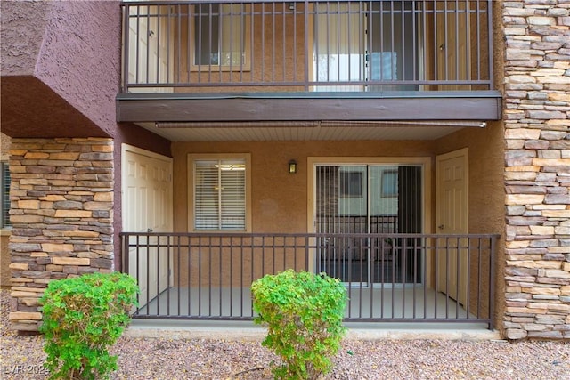 5260 River Glen Dr Unit 261, Las Vegas, NV 89103 - property entrance featuring a balcony, stone siding, and stucco siding