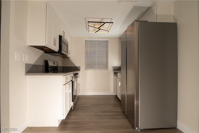 5260 River Glen Dr Unit 261, Las Vegas, NV 89103 - kitchen featuring stainless steel appliances, white cabinets, dark wood-style floors, and dark countertops