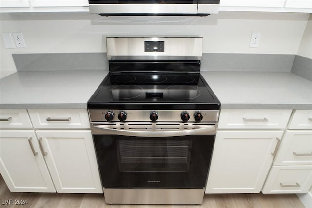 5260 River Glen Dr Unit 261, Las Vegas, NV 89103 - kitchen with stainless steel electric range oven, light countertops, white cabinets, and light wood-style floors