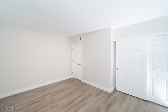 unfurnished bedroom featuring light hardwood / wood-style floors and a closet