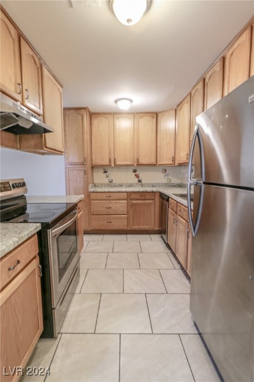 kitchen with light stone countertops, light brown cabinetry, light tile patterned floors, and stainless steel appliances