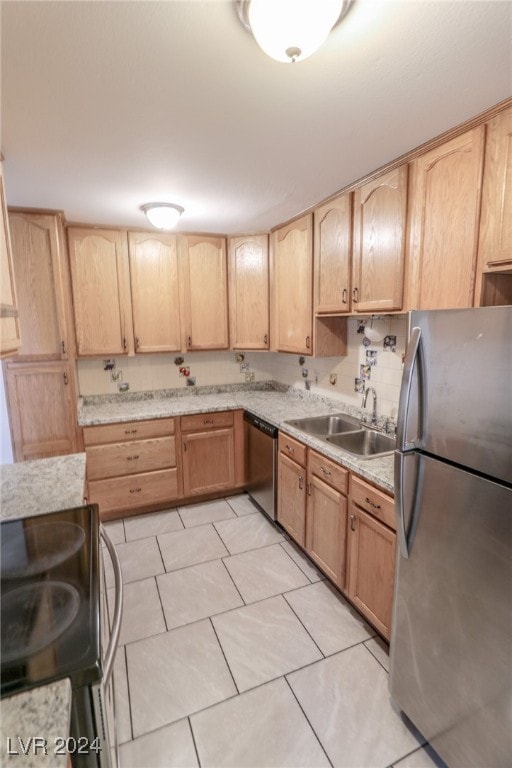 kitchen featuring light tile patterned flooring, appliances with stainless steel finishes, light brown cabinetry, and sink