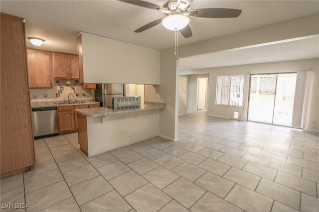 kitchen with ceiling fan, sink, kitchen peninsula, a breakfast bar, and appliances with stainless steel finishes