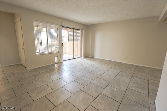 unfurnished room featuring light tile patterned floors and a textured ceiling