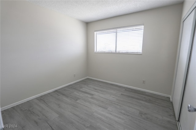 spare room featuring a textured ceiling and hardwood / wood-style flooring