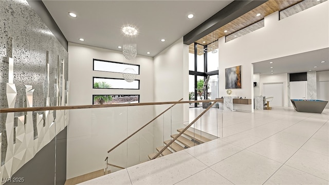 hallway featuring a high ceiling, recessed lighting, an upstairs landing, and tile patterned floors