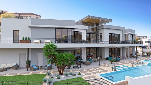 back of property featuring stucco siding, a fenced in pool, and a patio