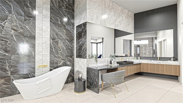 full bath featuring tile patterned floors, a high ceiling, a freestanding bath, vanity, and tile walls