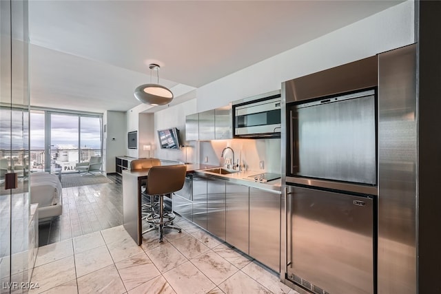 kitchen featuring black electric stovetop, floor to ceiling windows, and sink