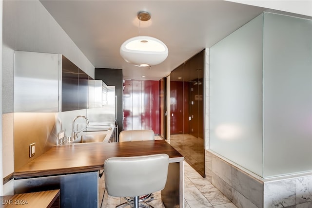 kitchen featuring a breakfast bar area, kitchen peninsula, and sink