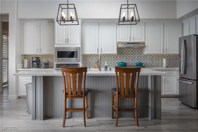 kitchen with decorative light fixtures, stainless steel appliances, and an inviting chandelier