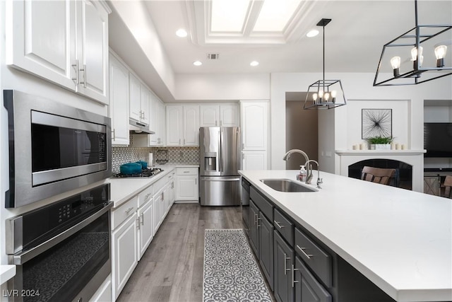 kitchen featuring hanging light fixtures, white cabinetry, sink, and appliances with stainless steel finishes