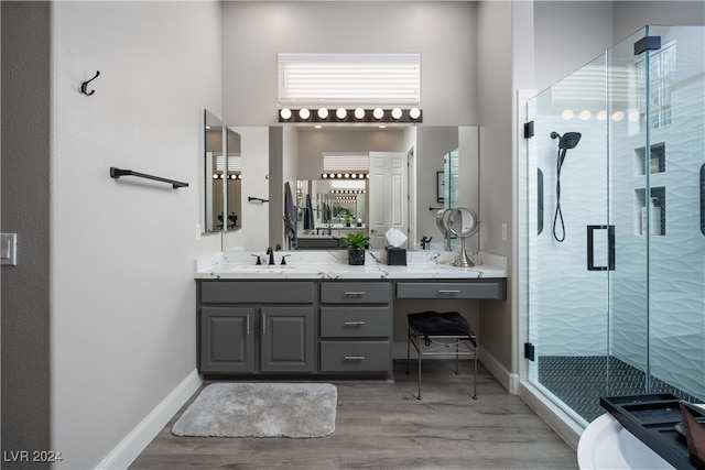 bathroom featuring vanity, hardwood / wood-style flooring, plenty of natural light, and a shower with door