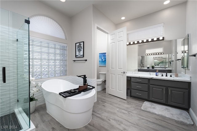 full bathroom featuring independent shower and bath, vanity, wood-type flooring, and toilet