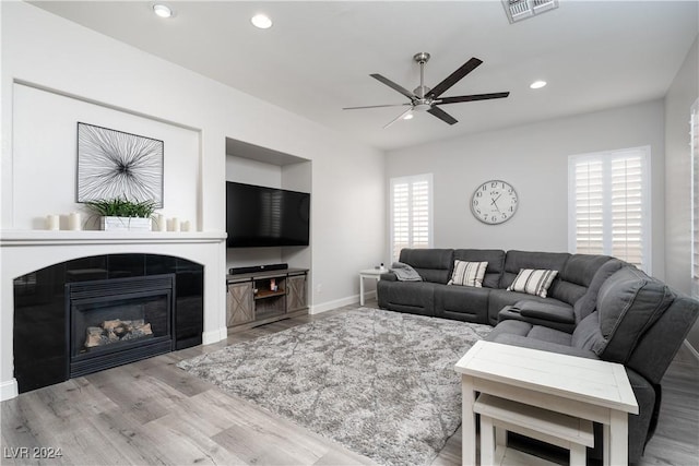 living room featuring ceiling fan and light hardwood / wood-style flooring