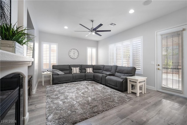 living room featuring ceiling fan, a healthy amount of sunlight, and light wood-type flooring