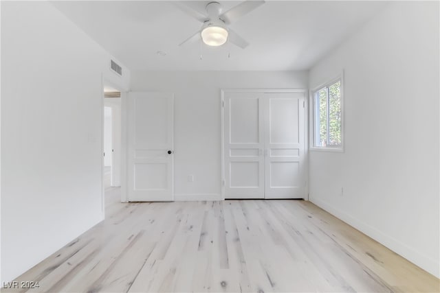 unfurnished bedroom with ceiling fan, light hardwood / wood-style floors, and a closet