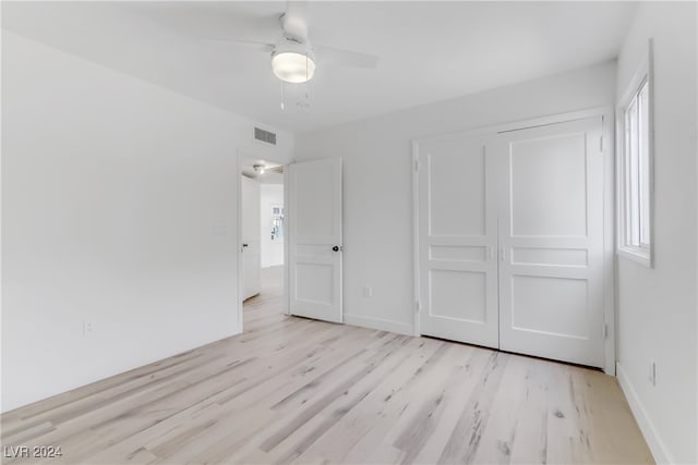 unfurnished bedroom featuring ceiling fan, light wood-type flooring, and a closet