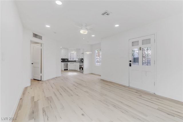 unfurnished living room featuring ceiling fan and light hardwood / wood-style floors