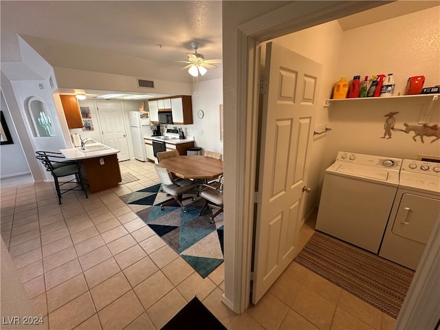 laundry area with washing machine and dryer, ceiling fan, sink, and light tile patterned floors